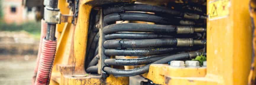 hidraulic flexible pressure pipes and tubes. Close-up of industrial bulldozer with oil leaks Сломалась техника - оплатим ремонт!