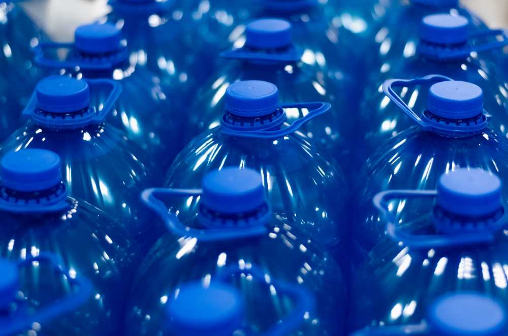 антифриз. Много синих химических жидких пластиковых бутылок. Группа бутылок крупным планом, выборочное размытие фокуса