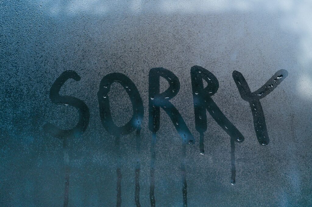 The word sorry on the wet glass.concept