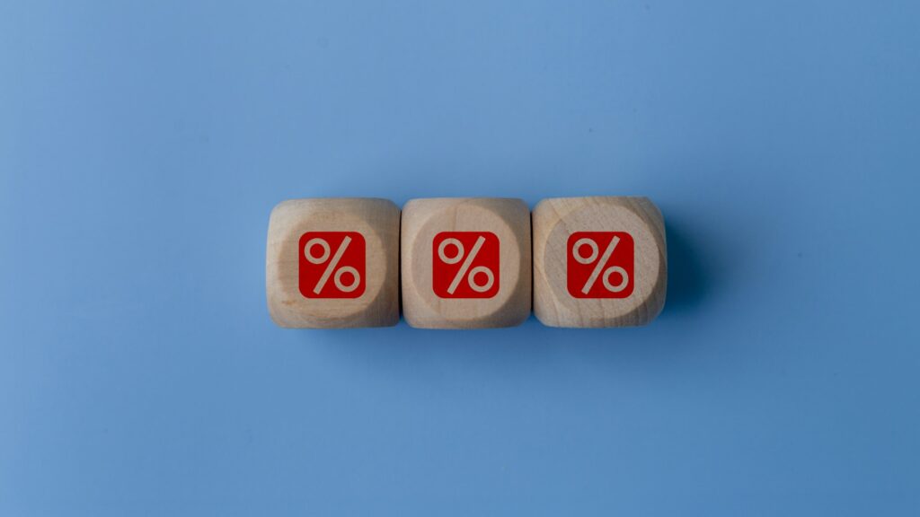 Three wooden cubes with a red percent sign. The cubes are stacked on top of each other